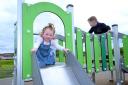 The play area has a castle-themed climbing unit, a toddler climbing unit, an accessible roundabout and trampoline, a range of swings including a basket swing, and a cable way