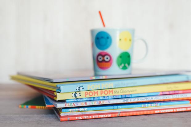 Central Fife Times: Children's books in a pile with a colourful mug on top. Credit: Canva
