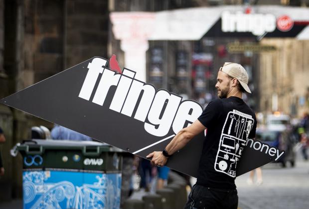 Central Fife Times: Man holding an Edinburgh Fringe sign. Credit: PA